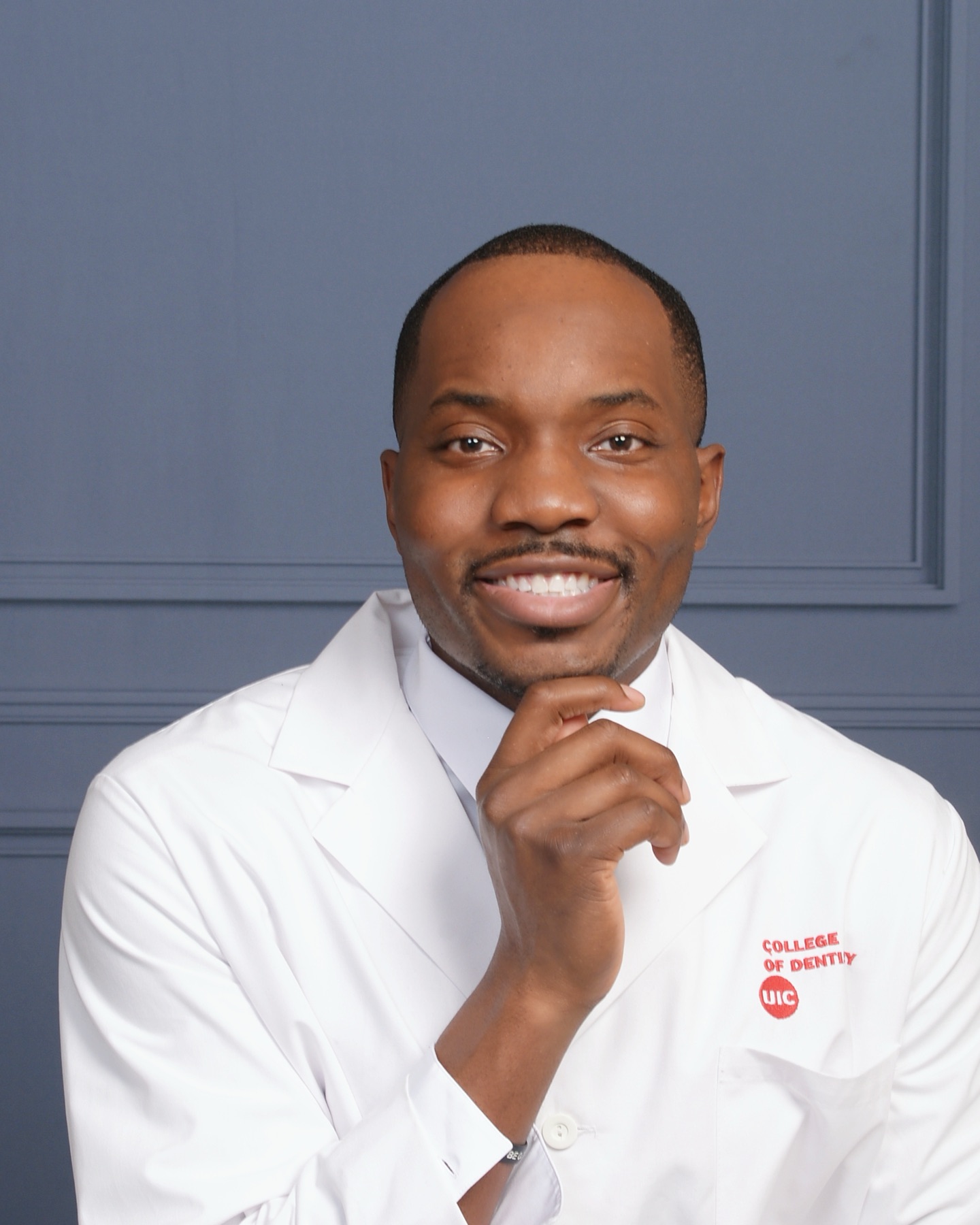 Dr. Bryant Ukaigwe, full-arch implant dentist, smiling in a white coat